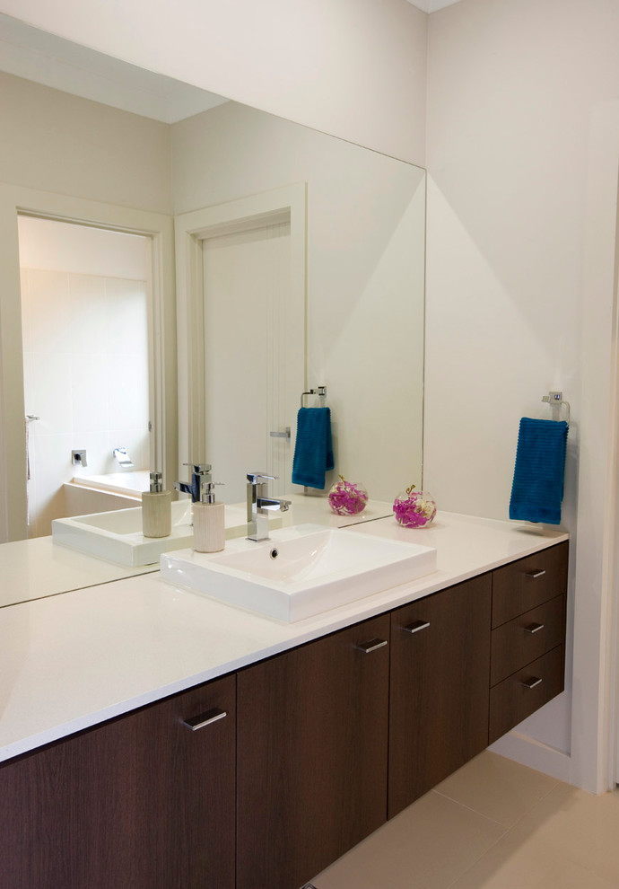 Inspiration for a mid-sized contemporary bathroom in Adelaide with a drop-in sink, dark wood cabinets, engineered quartz benchtops, beige tile, porcelain tile and porcelain floors.