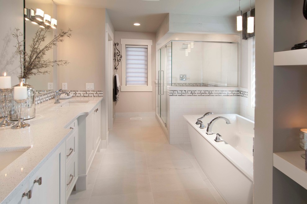 This is an example of a large traditional master bathroom in Calgary with subway tile, shaker cabinets, white cabinets, a freestanding tub, a corner shower, white tile, beige walls, an undermount sink and engineered quartz benchtops.