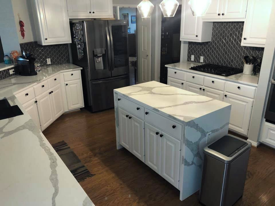 This is an example of a small transitional u-shaped eat-in kitchen in Austin with an undermount sink, recessed-panel cabinets, white cabinets, quartz benchtops, blue splashback, ceramic splashback, black appliances, plywood floors, with island, brown floor and multi-coloured benchtop.