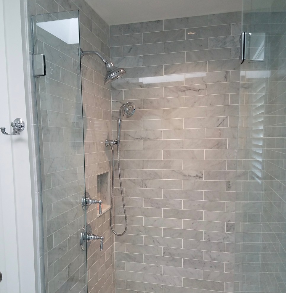 Mid-sized transitional 3/4 bathroom in Bridgeport with recessed-panel cabinets, grey cabinets, an alcove shower, a one-piece toilet, gray tile, subway tile, white walls, marble floors, an undermount sink, marble benchtops, grey floor and a hinged shower door.