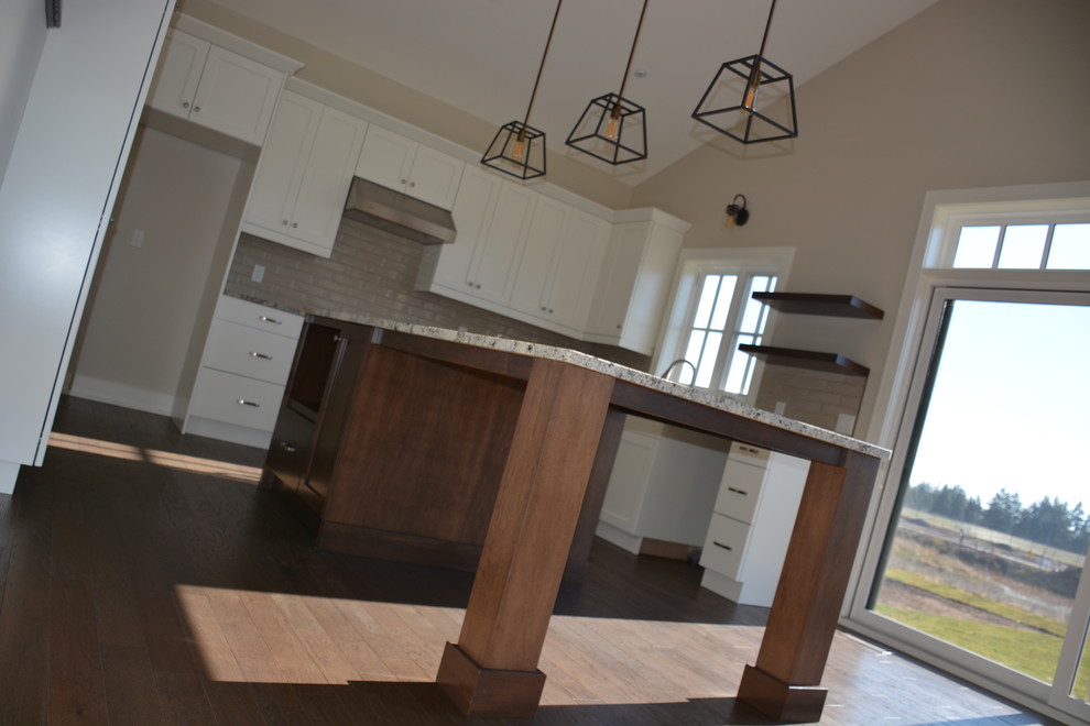 Inspiration for a mid-sized transitional u-shaped light wood floor eat-in kitchen remodel in Toronto with a double-bowl sink, shaker cabinets, white cabinets, granite countertops, gray backsplash, subway tile backsplash, stainless steel appliances and an island