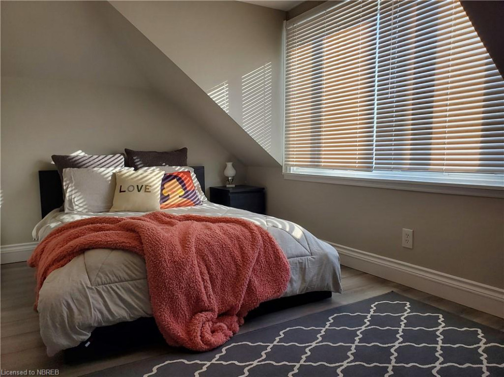 Example of a small cottage master laminate floor and gray floor bedroom design in Other with gray walls
