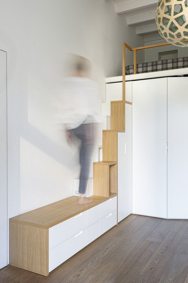 ミラノにある高級な小さなコンテンポラリースタイルのおしゃれな直階段 (フローリングの蹴込み板、木材の手すり) の写真