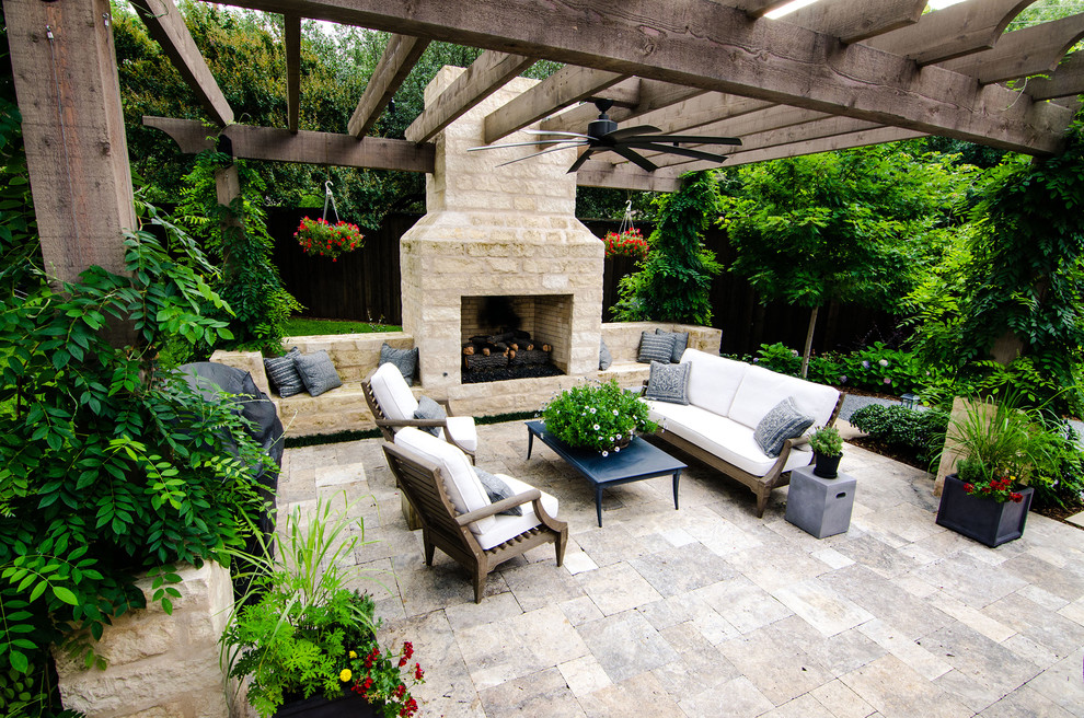 This is an example of a mid-sized transitional backyard patio in Dallas with a fire feature, natural stone pavers and a pergola.