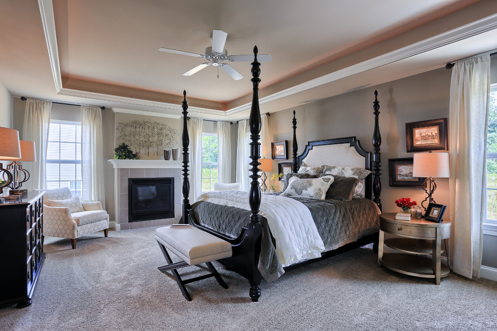 Large transitional master carpeted bedroom photo with gray walls, a standard fireplace and a tile fireplace