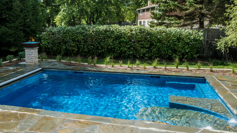 Inspiration for a mid-sized rustic backyard stone and rectangular lap pool fountain remodel in Chicago