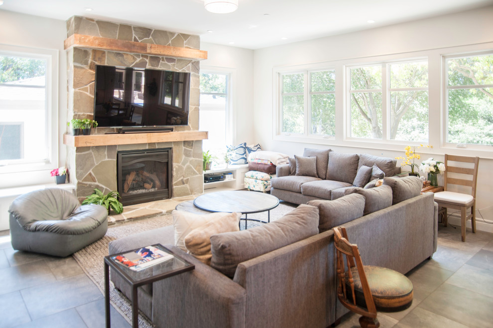 This is an example of a large contemporary open concept family room in San Francisco with beige walls, ceramic floors, a standard fireplace, a stone fireplace surround and a wall-mounted tv.