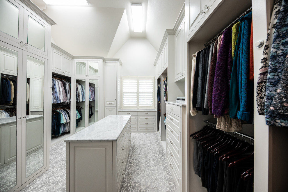 This is an example of a large traditional gender-neutral walk-in wardrobe in Dallas with beaded inset cabinets, white cabinets, carpet, grey floor and vaulted.