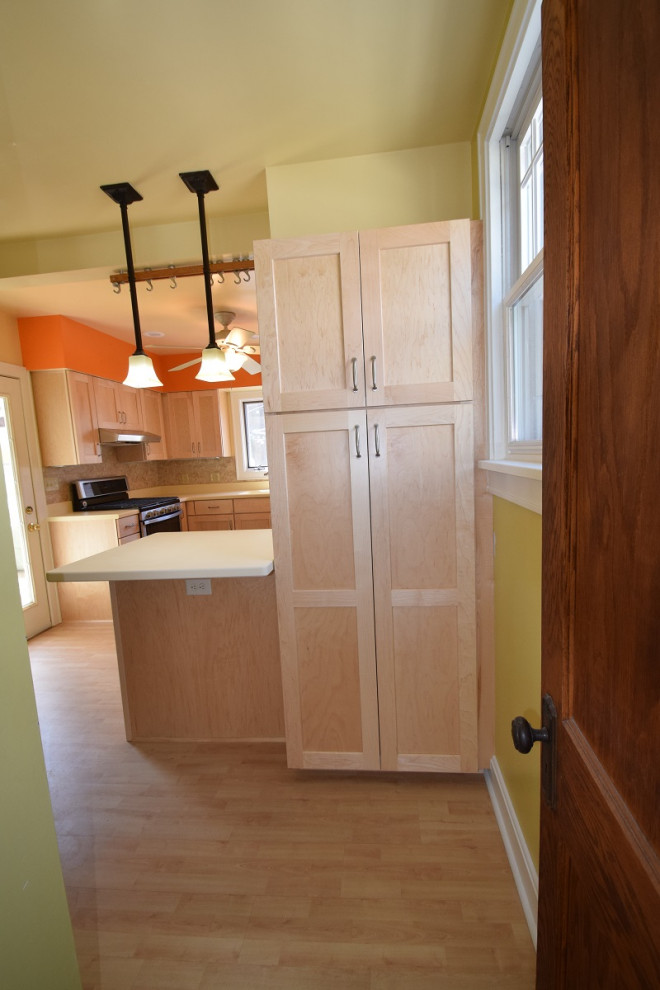 Mid-sized transitional u-shaped light wood floor kitchen photo with an integrated sink, shaker cabinets, light wood cabinets, multicolored backsplash, stone tile backsplash, a peninsula and white countertops