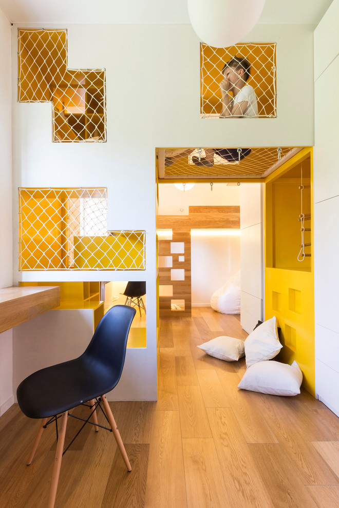 Contemporary gender-neutral kids' playroom in Moscow with white walls and medium hardwood floors for kids 4-10 years old.