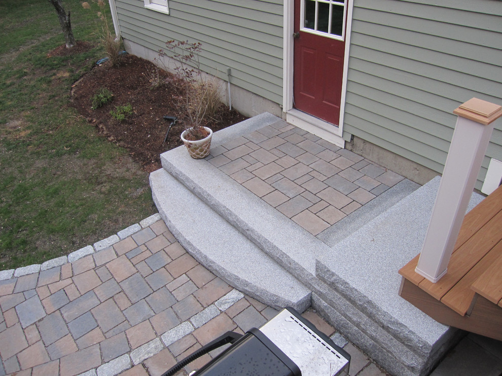 Large traditional backyard patio in Providence with concrete pavers.