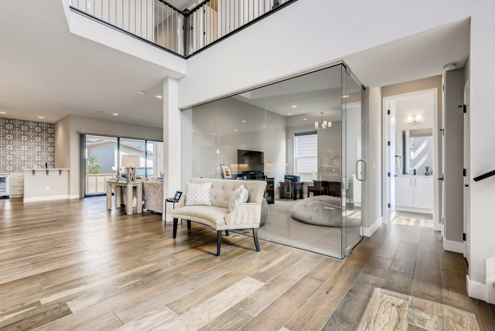 Expansive contemporary foyer in Denver with medium hardwood floors and a white front door.
