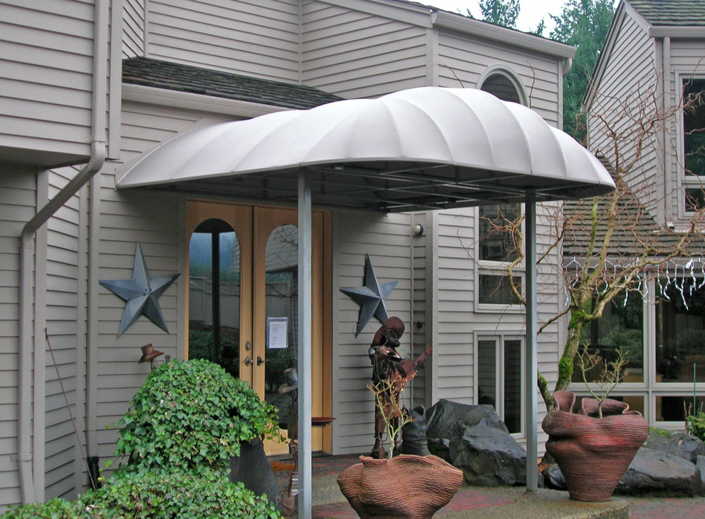 This is an example of a small traditional front yard patio in Portland with gravel and an awning.