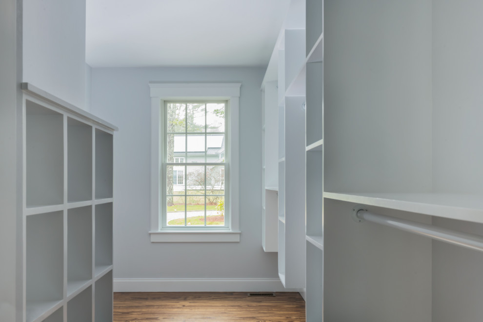 Photo of a mid-sized transitional gender-neutral walk-in wardrobe in Boston with open cabinets, white cabinets, dark hardwood floors and brown floor.