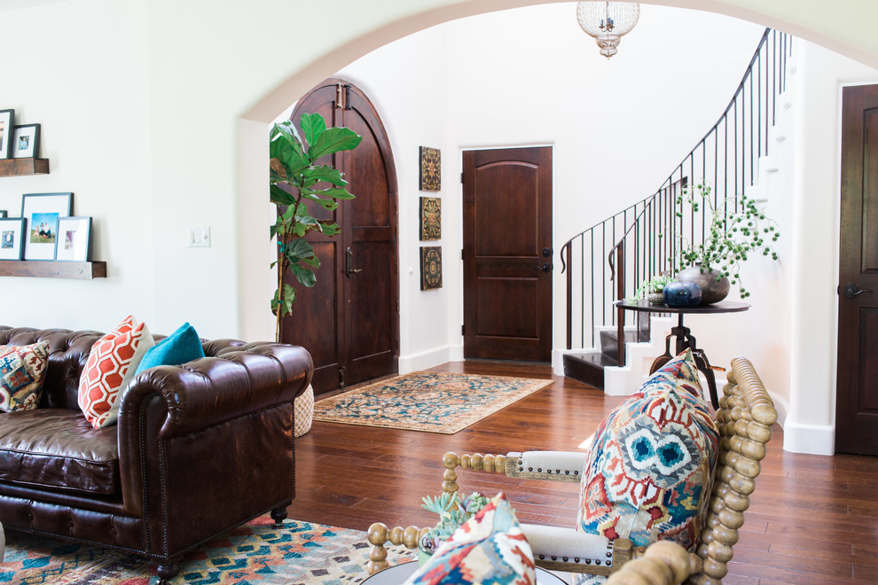 Photo of a large front door in Austin with white walls, dark hardwood floors, a double front door, a dark wood front door and brown floor.