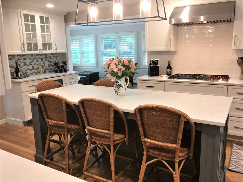 Large transitional galley light wood floor and brown floor eat-in kitchen photo in Boston with an undermount sink, shaker cabinets, white cabinets, quartz countertops, white backsplash, subway tile backsplash, stainless steel appliances, two islands and white countertops