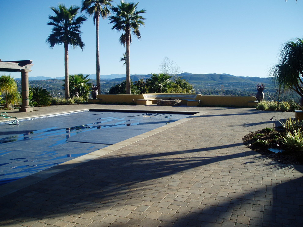Design ideas for a large mediterranean backyard patio in San Diego with a fire feature and brick pavers.