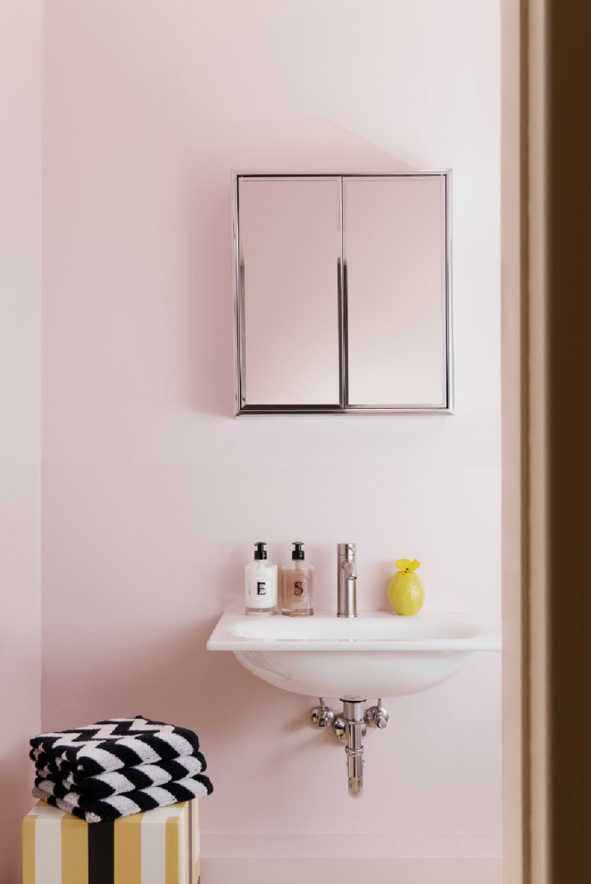 Cette image montre un petit WC et toilettes bohème avec un mur rose, un lavabo encastré, un plan de toilette blanc, meuble-lavabo sur pied et du papier peint.
