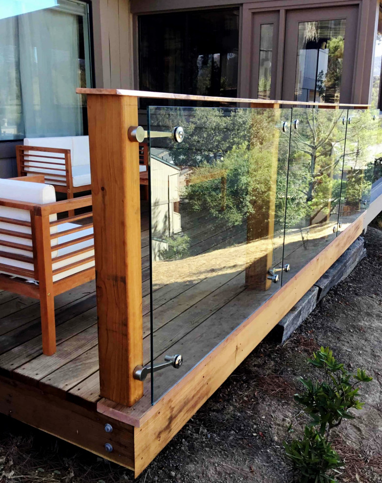 This is an example of a small modern side yard and ground level deck in San Francisco with glass railing.