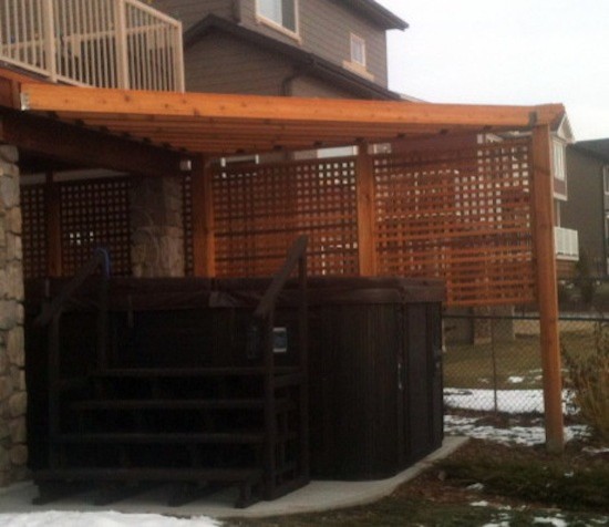 Backyard patio in Calgary with a water feature, gravel and an awning.