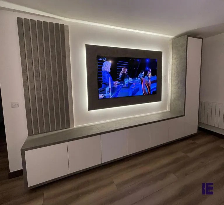 Photo of a large modern open concept home theatre in London with grey walls, plywood floors and a wall-mounted tv.