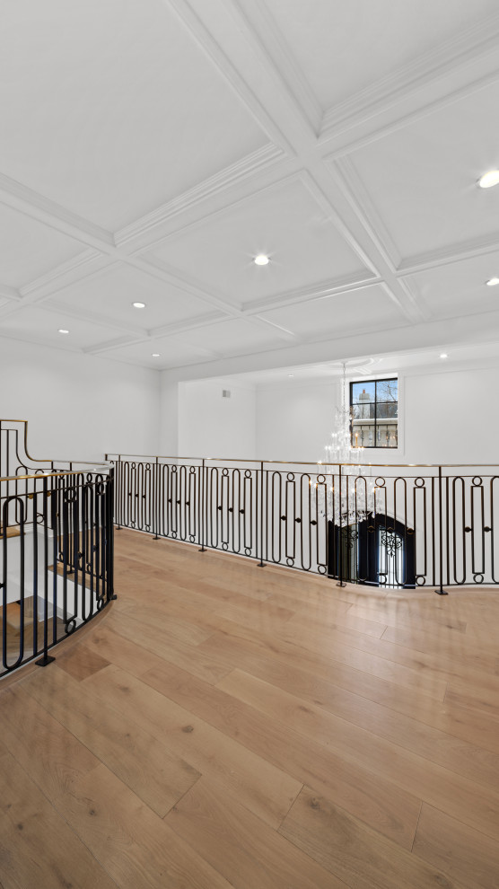 Hallway - large modern light wood floor, brown floor and coffered ceiling hallway idea in Chicago with white walls