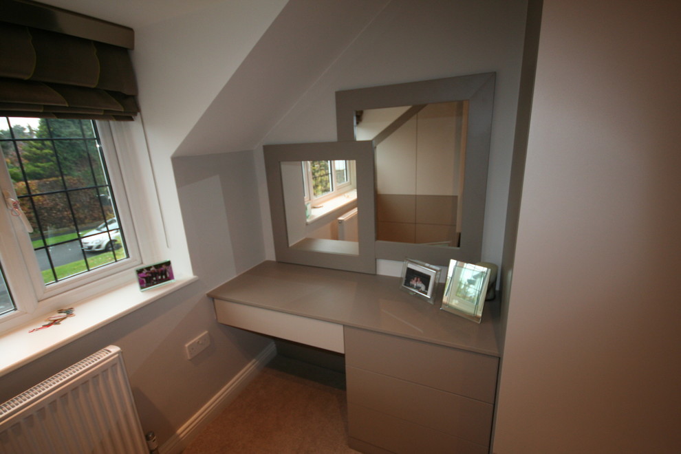 Photo of a transitional master bedroom in Manchester with beige walls and carpet.