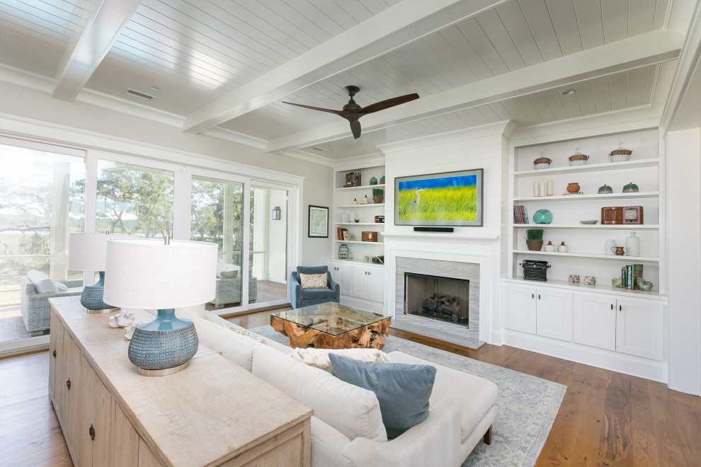 Inspiration for a transitional open concept living room in Charleston with white walls, medium hardwood floors, a standard fireplace, a stone fireplace surround, a wall-mounted tv, brown floor, exposed beam, timber and planked wall panelling.