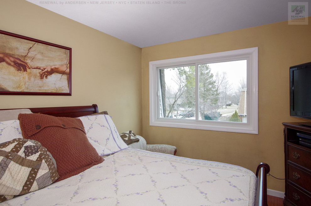 Kleines Schlafzimmer ohne Kamin mit gelber Wandfarbe und dunklem Holzboden in Newark