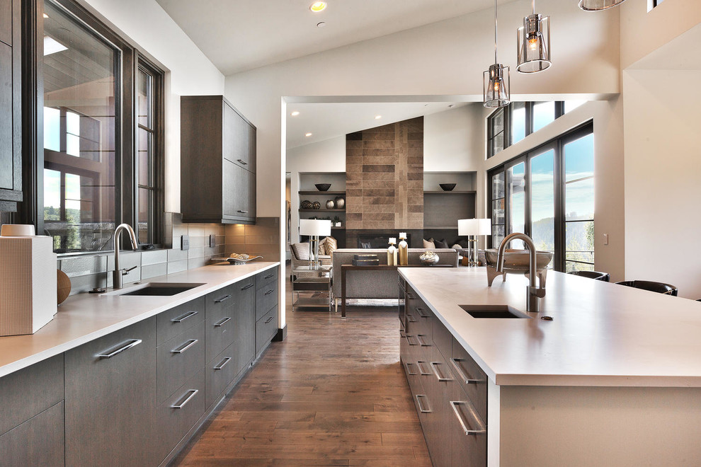 Design ideas for an expansive contemporary galley eat-in kitchen in Salt Lake City with an undermount sink, flat-panel cabinets, grey cabinets, quartz benchtops, grey splashback, glass tile splashback, stainless steel appliances, medium hardwood floors, with island and grey floor.