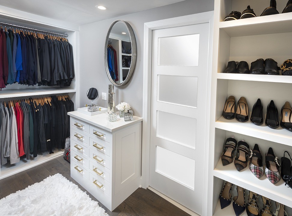 Photo of a small transitional gender-neutral walk-in wardrobe in Philadelphia with recessed-panel cabinets, white cabinets, dark hardwood floors and brown floor.