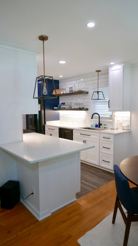 Eat-in kitchen - mid-sized transitional galley porcelain tile and gray floor eat-in kitchen idea with an undermount sink, shaker cabinets, white cabinets, quartz countertops, white backsplash, subway tile backsplash, black appliances, no island and white countertops