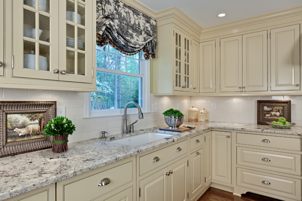 Expansive traditional u-shaped eat-in kitchen in Atlanta with an undermount sink, beaded inset cabinets, beige cabinets, granite benchtops, white splashback, subway tile splashback, stainless steel appliances, medium hardwood floors, with island, brown floor and white benchtop.