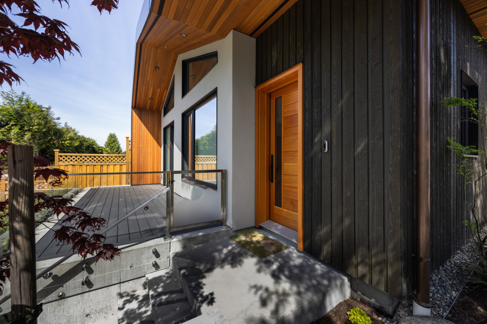 Стильный дизайн: маленький, двухэтажный мини дом в современном стиле с комбинированной облицовкой, двускатной крышей, зеленой крышей, черной крышей и отделкой доской с нащельником для на участке и в саду - последний тренд