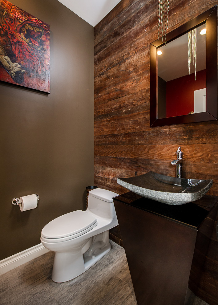 This is an example of a small traditional powder room in Los Angeles with a one-piece toilet, gray tile, brown walls, porcelain floors and a pedestal sink.