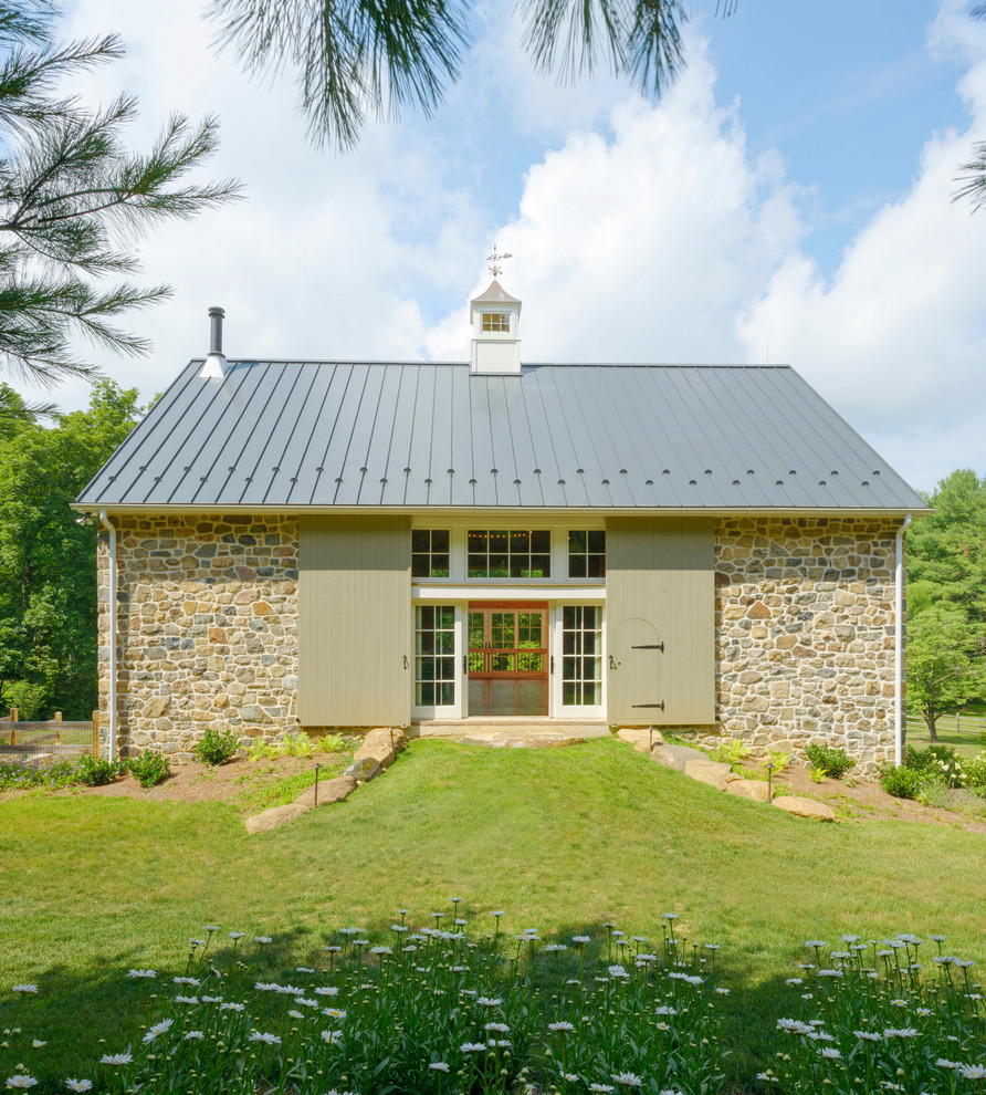 Country two-storey white exterior in Philadelphia with stone veneer and a gable roof.