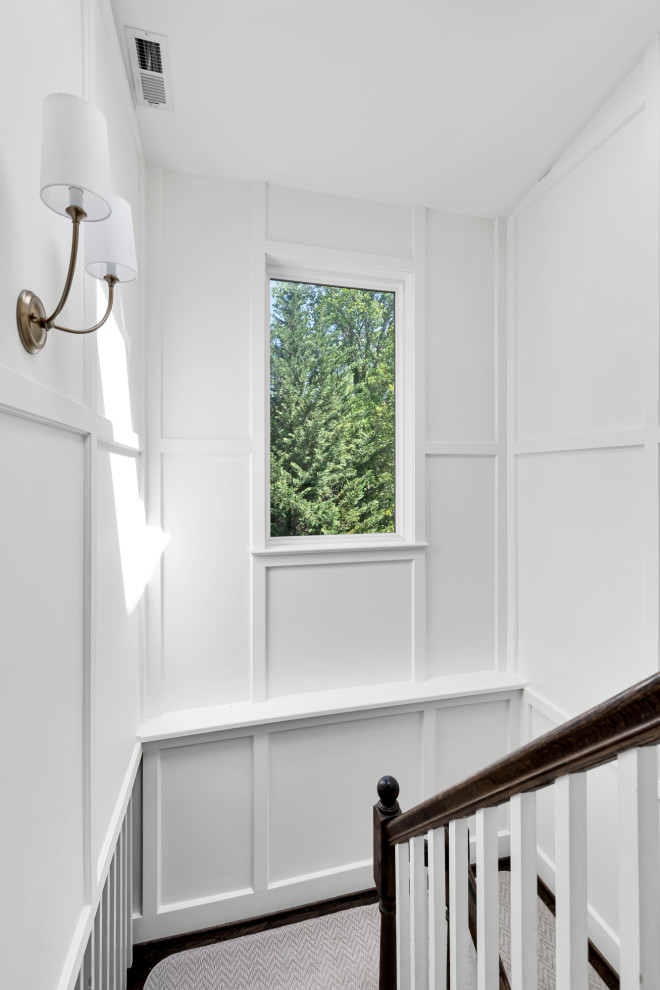 Large transitional u-shaped wood railing and wainscoting staircase photo in DC Metro