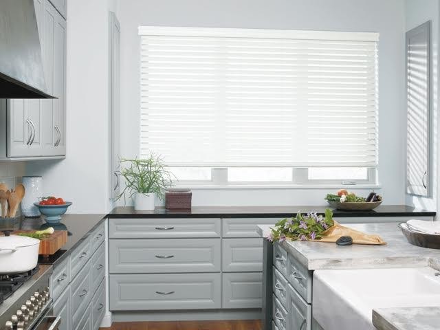 Inspiration for a mid-sized transitional l-shaped medium tone wood floor and brown floor enclosed kitchen remodel in Miami with a farmhouse sink, raised-panel cabinets, gray cabinets, quartz countertops, stainless steel appliances and an island