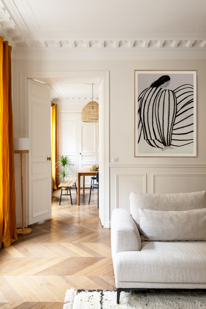 パリにある高級な広いコンテンポラリースタイルのおしゃれなリビング (ベージュの壁、無垢フローリング、据え置き型テレビ、茶色い床、羽目板の壁) の写真