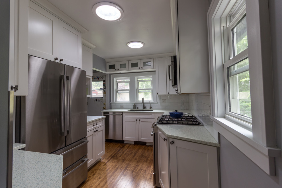 Traditional kitchen in Minneapolis with a drop-in sink, recycled glass benchtops, white splashback, ceramic splashback and medium hardwood floors.