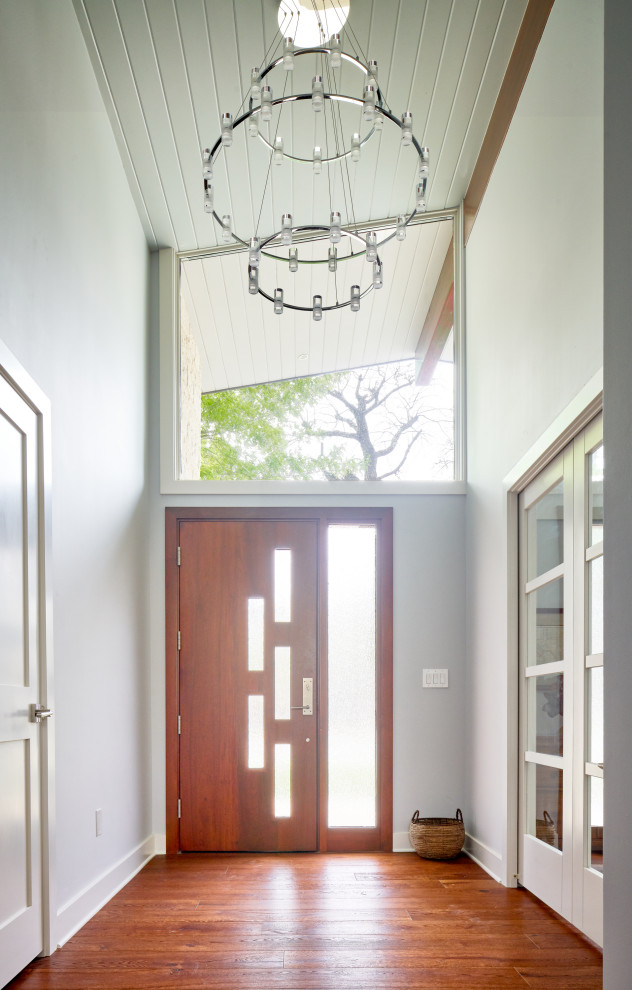 Aménagement d'une entrée rétro avec un mur gris, un sol en bois brun, une porte simple, une porte en bois brun et un plafond en lambris de bois.