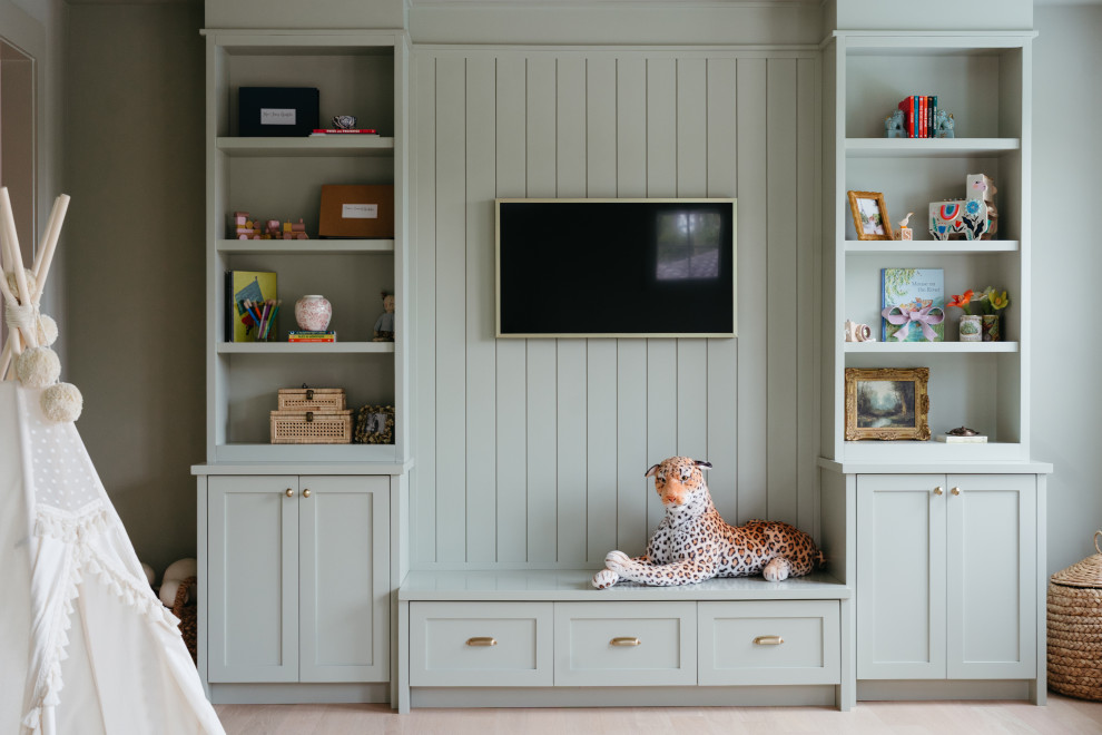 Custom Playroom Built-In Cabinets with TV Wall and Bench Storage - This custom playroom built-in cabinetry project was designed to create both organization and visual structure in a busy family space. The wall-to-wall built-ins feature open shelving for books and toys, closed cabinets for hidden storage, and a central vertical paneled wall that anchors the television.
The integrated bench with deep drawers adds additional storage while creating a comfortable spot for reading or relaxing. By combining open shelving with concealed cabinetry, the design allows everyday playroom items to stay accessible while maintaining a clean and organized appearance.
Every piece was custom built to fit the room perfectly, maximizing storage while creating a cohesive architectural feature that blends seamlessly with the home’s interior.
