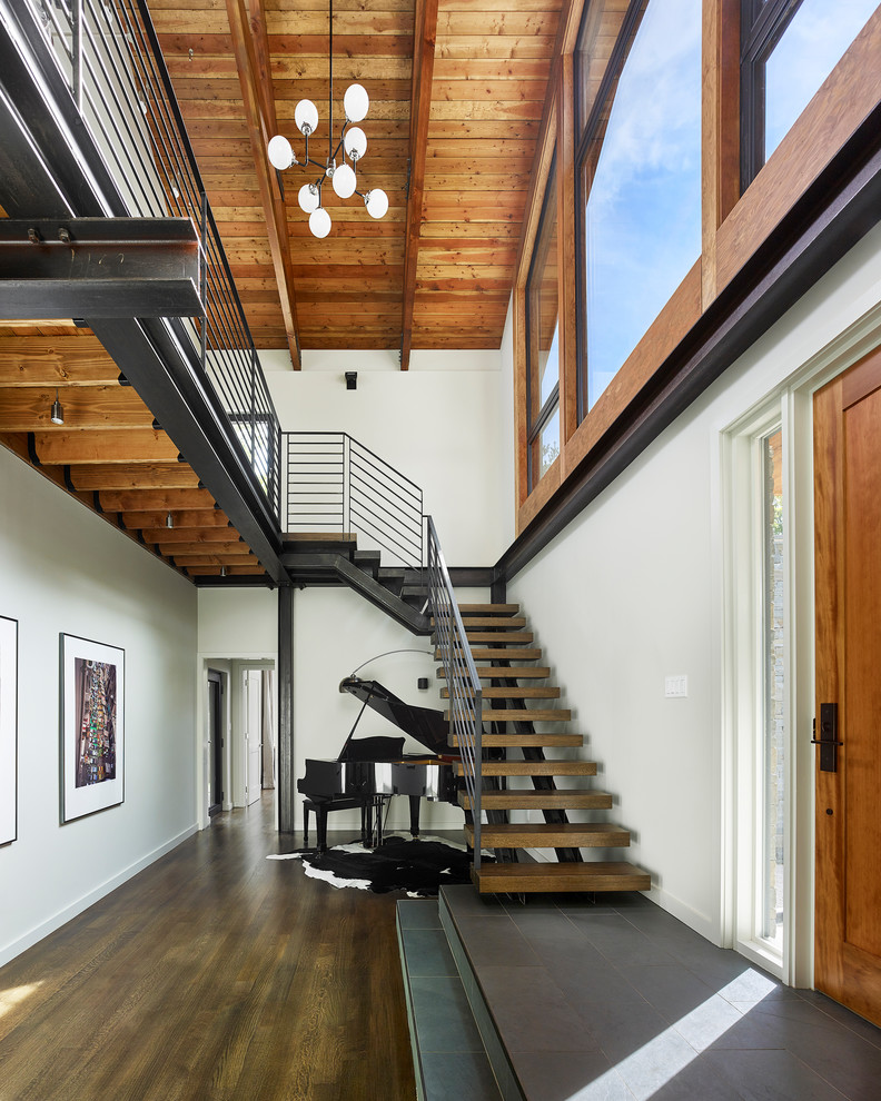 Photo of a large contemporary wood l-shaped staircase in Philadelphia with open risers and metal railing.