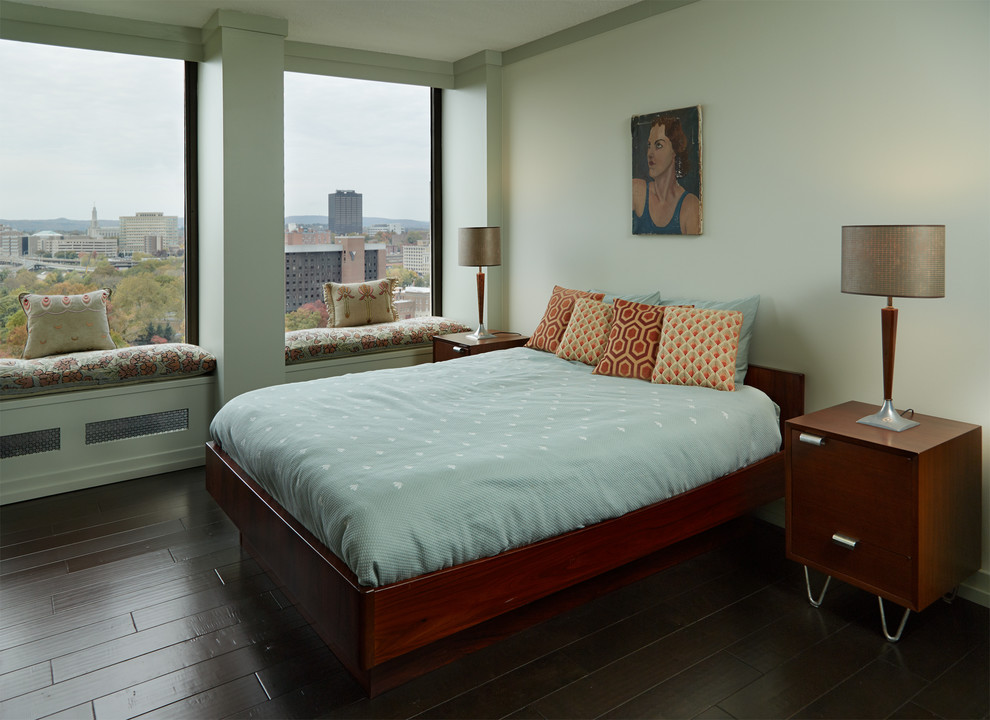 Small midcentury master bedroom in New York with green walls, dark hardwood floors and black floor.