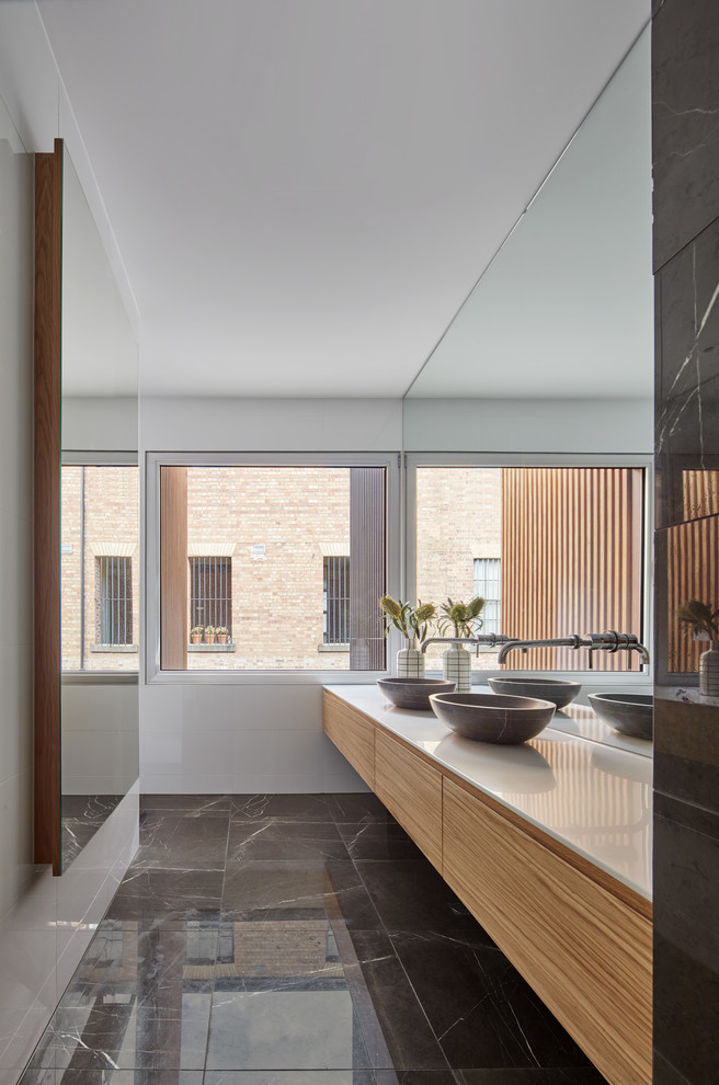 Inspiration for a mid-sized contemporary master bathroom in Melbourne with open cabinets, white walls, a vessel sink, solid surface benchtops, white benchtops, medium wood cabinets, white tile and grey floor.