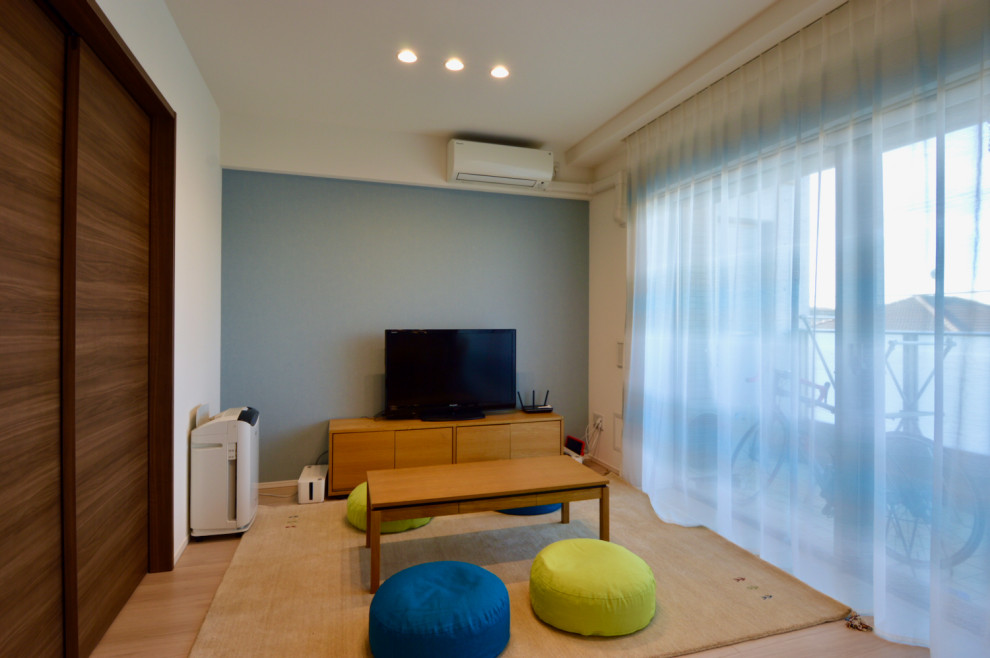 Mittelgroßes, Offenes Nordisches Wohnzimmer ohne Kamin mit blauer Wandfarbe, braunem Holzboden, TV-Wand, Tapetendecke und Tapetenwänden in Tokio