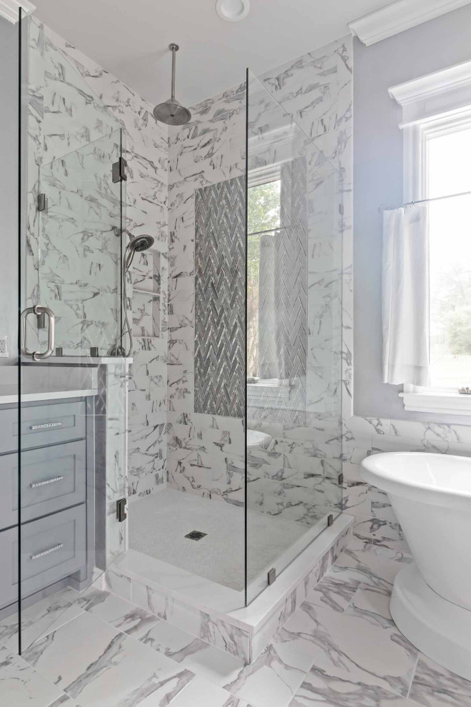 Bathroom in Other with grey cabinets, a freestanding bath, a corner shower, grey tiles, marble tiles, grey walls, marble flooring, marble worktops, a hinged door, white worktops, an enclosed toilet and double sinks.
