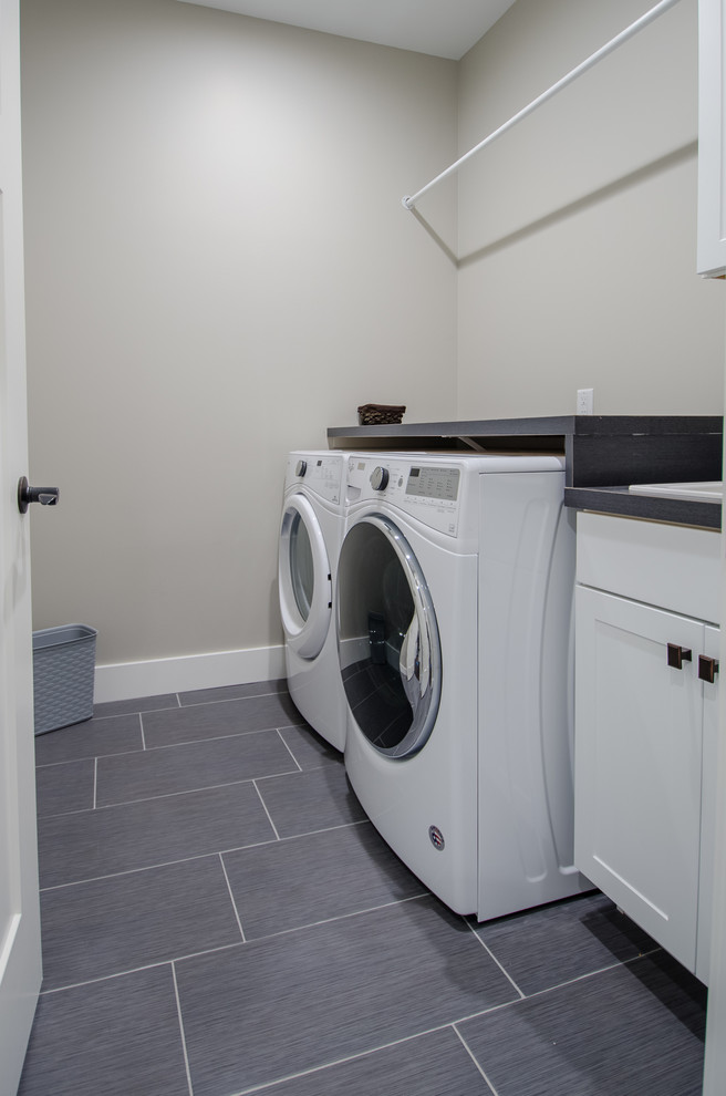Dedicated laundry room - mid-sized transitional single-wall vinyl floor dedicated laundry room idea with a drop-in sink, shaker cabinets, white cabinets, laminate countertops, beige walls and a side-by-side washer/dryer