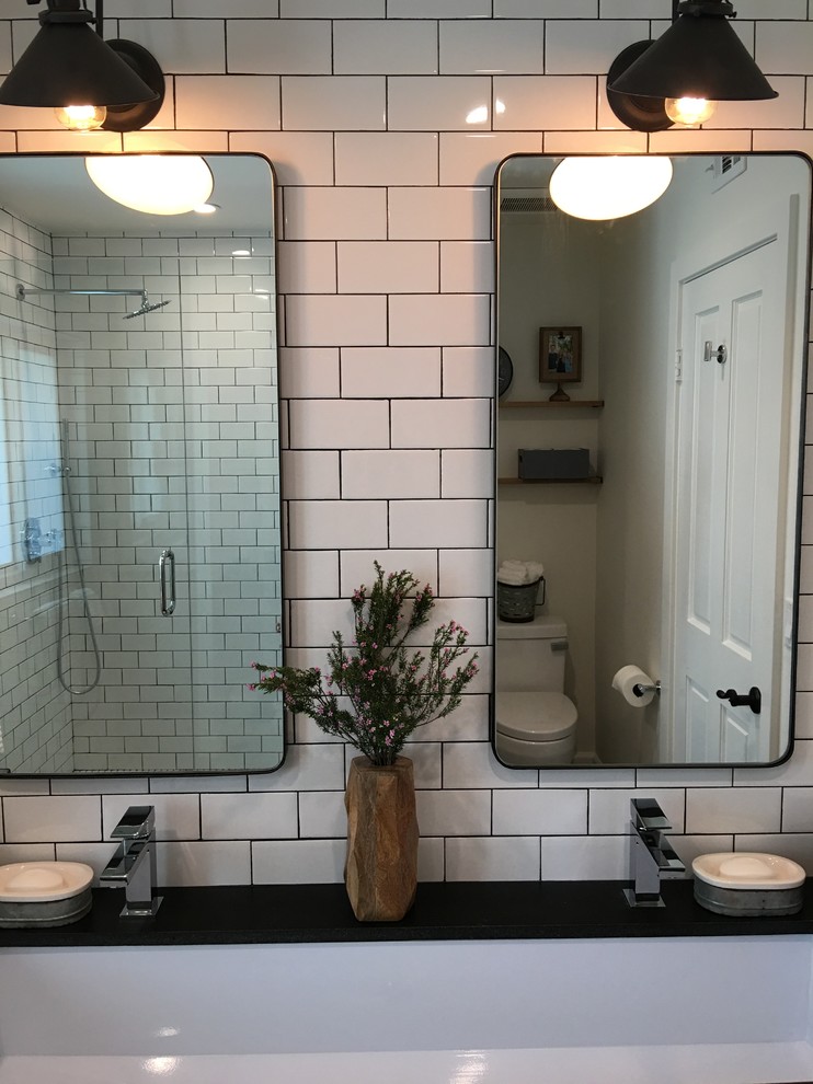 Photo of a mid-sized industrial kids bathroom in Los Angeles with open cabinets, medium wood cabinets, an alcove shower, a one-piece toilet, white tile, subway tile, white walls, ceramic floors, a trough sink and granite benchtops.