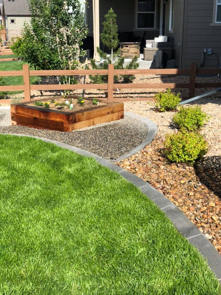 Inspiration for a large traditional backyard full sun xeriscape in Denver with with lawn edging, river rock and a wood fence.